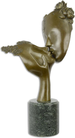 A BRONZE SCULPTURE OF TWO FACES KISSING