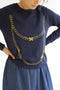Donkerblauwe sweater met een gouden print van een ketting.