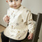 Nuuroo slabbetje met mouwen - Circus / beige